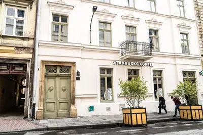 a white building with a sign for a shop at Avium Old Town Apartments in Kraków