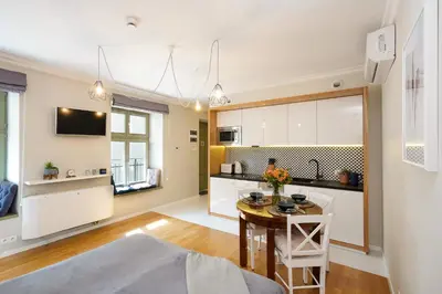 a kitchen and living room with a table and chairs at Avium Old Town Apartments in Kraków
