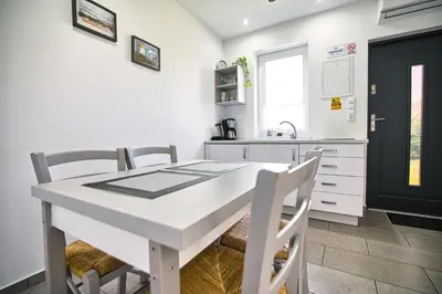 a white kitchen with a white table and chairs at Apartamenty i Domki u Basi in Zator
