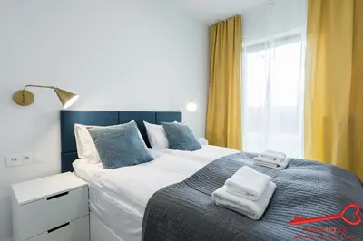 a bedroom with a large bed with two towels on it at Apartments Nearto Old Town Rakowicka in Kraków