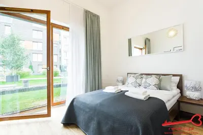 a bedroom with a bed with a mirror and a window at Apartments Nearto Old Town Rakowicka in Kraków