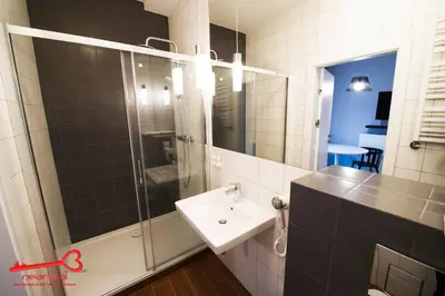 a bathroom with a sink and a glass shower at Apartments Nearto Old Town Rakowicka in Kraków
