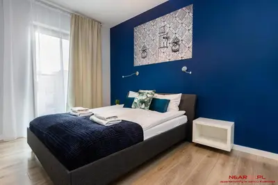 a bedroom with blue walls and a bed with towels on it at Apartments Nearto Old Town Rakowicka in Kraków