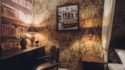 a room with a desk and a table with a lamp at Main Street Apartments in Kraków