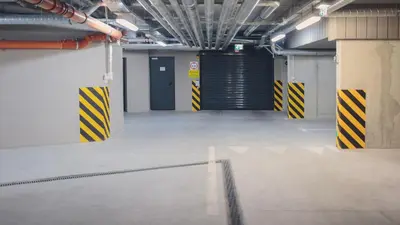 an empty parking garage with blue and yellow doors at Main Street Apartments in Kraków