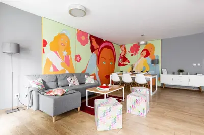 a living room with a couch and a painting on the wall at Apartments Kremer Cracow in Kraków