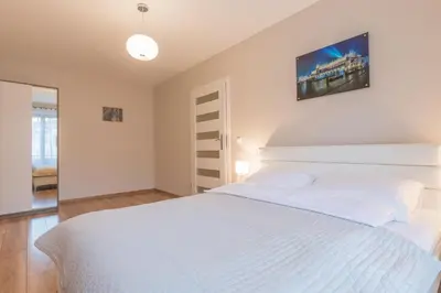 a white bedroom with a large white bed at Apartments Kremer Cracow in Kraków