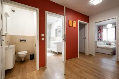 a bathroom with a toilet and a sink and a bedroom at Apartments Kremer Cracow in Kraków