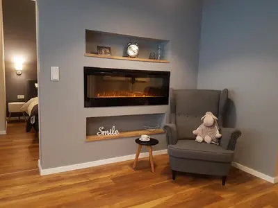a living room with a chair and a fireplace at Gertrudy Old Town Apartments in Kraków