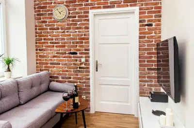 a living room with a brick wall and a couch at Gertrudy Old Town Apartments in Kraków