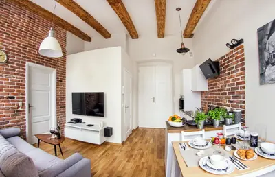 an open kitchen and living room with a brick wall at Gertrudy Old Town Apartments in Kraków