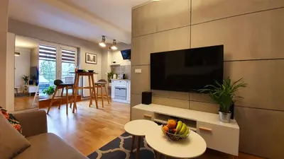a living room with a television and a table with a bowl of fruit at Gertrudy Old Town Apartments in Kraków