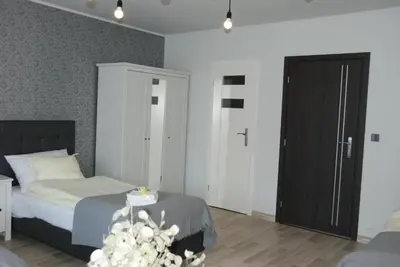 a bedroom with a bed and a black door at 7th Room Guest House in Oświęcim