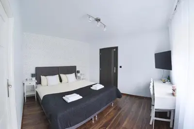 a bedroom with a bed and a table and a desk at 7th Room Guest House in Oświęcim
