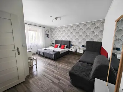 a bedroom with a bed and a couch at 7th Room Guest House in Oświęcim