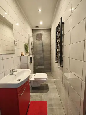 a bathroom with a sink and a toilet and a shower at 7th Room Guest House in Oświęcim