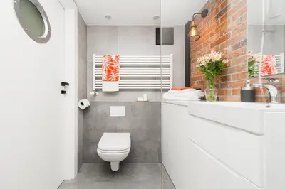 a bathroom with a white toilet and a sink at Lofts Cracow Apartments - City Center in Kraków