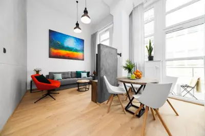 a living room with a table and chairs and a couch at Lofts Cracow Apartments - City Center in Kraków