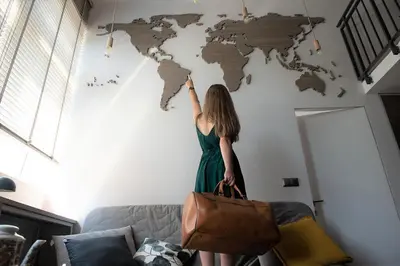 a woman standing in front of a world map on a wall at Lofts Cracow Apartments - City Center in Kraków