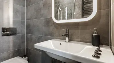a bathroom with a sink and a mirror at Happy Apartments in Kraków