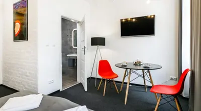 a room with a table and two red chairs at Happy Apartments in Kraków