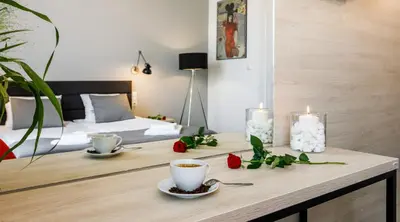 a table with two cups of coffee and a candle at Happy Apartments in Kraków