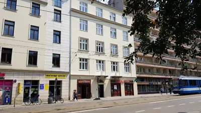 a blue bus parked in front of a white building at Happy Apartments in Kraków