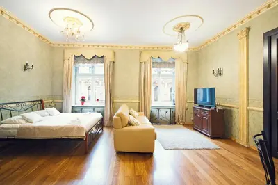 a bedroom with a bed and a couch and a tv at Calliope Apartments in Kraków