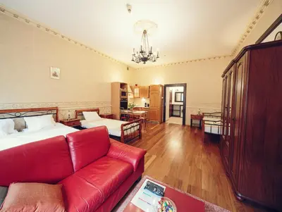 a living room with a red couch and a bed at Calliope Apartments in Kraków