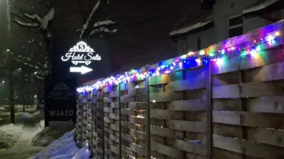 a fence with christmas lights on it at Salis Resort in Wieliczka