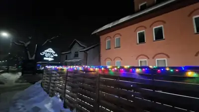 a fence with christmas lights in front of a building at Salis Resort in Wieliczka