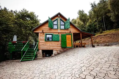 a small wooden house with green doors and a staircase at Świerkowe Zacisze Domki in Budzów