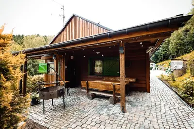 a small cabin with a bench in front of it at Świerkowe Zacisze Domki in Budzów