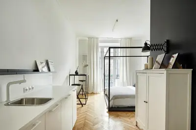 a white kitchen with a sink and a bedroom at FOUR STORIES APARTMENTS - Krasinskiego in Kraków