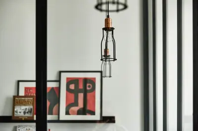 a chandelier hanging over a shelf with framed pictures at FOUR STORIES APARTMENTS - Krasinskiego in Kraków