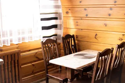 a dining room with a wooden table and chairs at Apartamenty Gorczańskie in Rabka