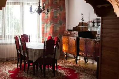 a dining room with a table and a kitchen at Apartamenty Gorczańskie in Rabka