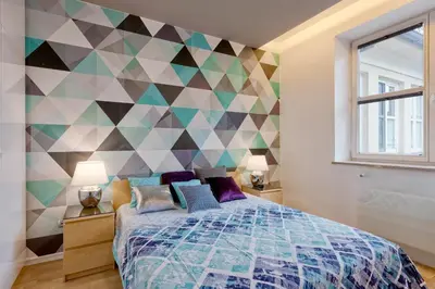 a bedroom with a bed and a geometric wall at Centre Apartments-Old Town in Kraków