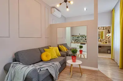 a living room with a gray couch and yellow pillows at Centre Apartments-Old Town in Kraków