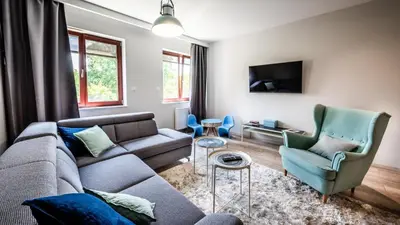 a living room with a couch and two chairs at A11 Apartments & SPA Dermique in Kraków