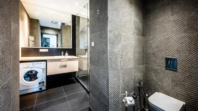 a bathroom with a sink and a washing machine at A11 Apartments & SPA Dermique in Kraków