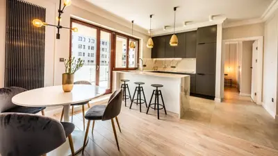 a kitchen and dining room with a table and chairs at A11 Apartments & SPA Dermique in Kraków