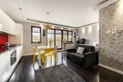 a kitchen and living room with a table and a couch at A11 Apartments & SPA Dermique in Kraków