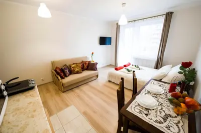 a living room with a table and a living room with a couch at Apartament Polonijna in Kraków