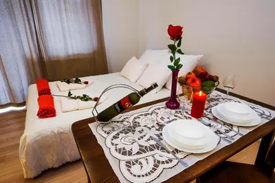 a table with two plates and a bottle of wine at Apartament Polonijna in Kraków