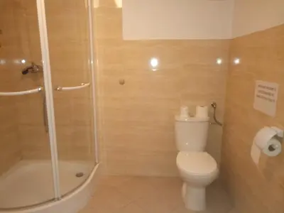 a bathroom with a toilet and a glass shower at Dom Franciszkański San Antonio in Kraków