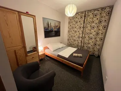 a small bedroom with a bed and a chair at Dom Franciszkański San Antonio in Kraków