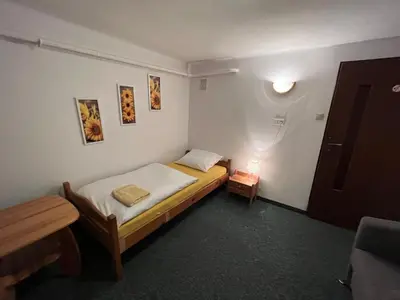 a small bedroom with a bed and a lamp at Dom Franciszkański San Antonio in Kraków