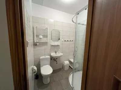 a small bathroom with a toilet and a sink at Dom Franciszkański San Antonio in Kraków