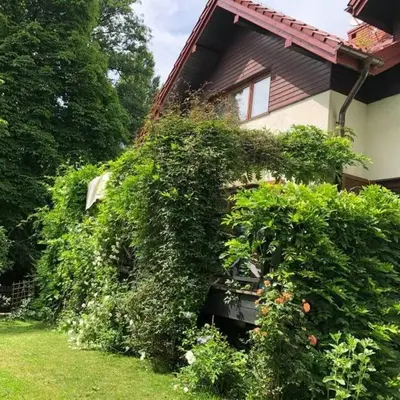 a house with a bunch of bushes in front of it at Leśna 6 - House with a garden in Bolechowice